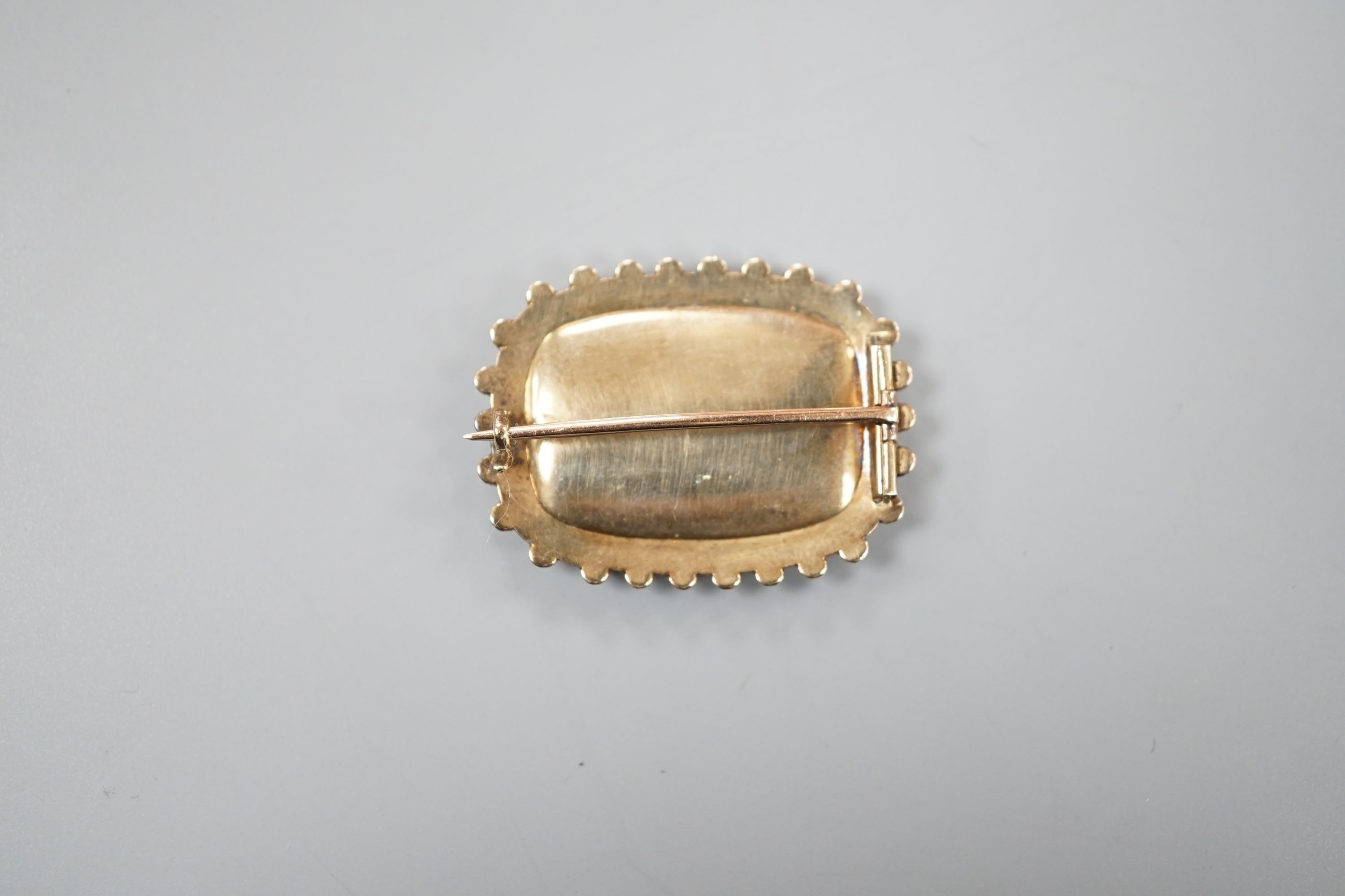 A 19th century yellow metal and seed pearl brooch, with glazed floral motif, 31mm, gross weight 6.1 grams.